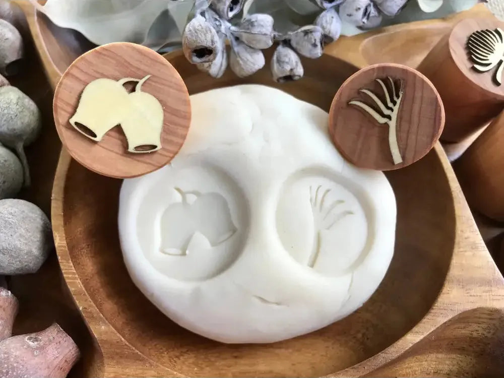 Clay mold with imprints of a bell and a hand shape.