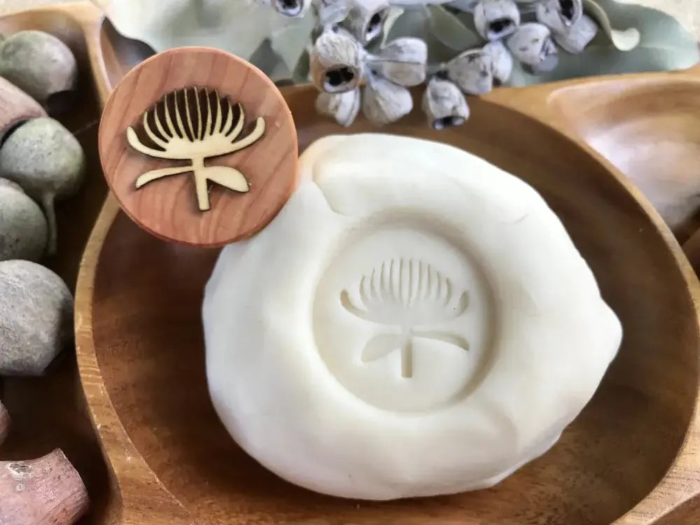 Clay stamp with a dandelion design for imprinting patterns.