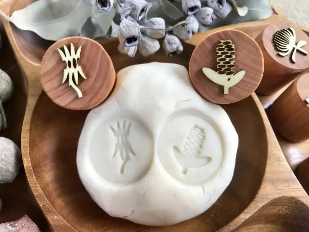 Clay or ceramic mold with two circular impressions for creating decorative patterns.