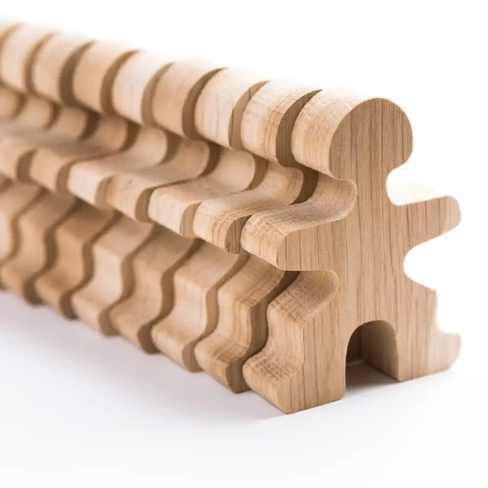 Wooden puzzle piece with a wavy, ridged surface along its length.