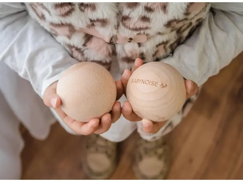 Two wooden eggs held in cupped hands.