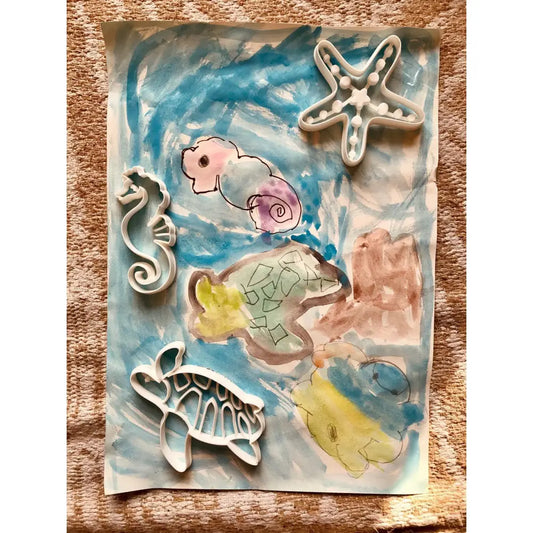 Watercolor painting featuring sea creatures and shapes in pastel colors.