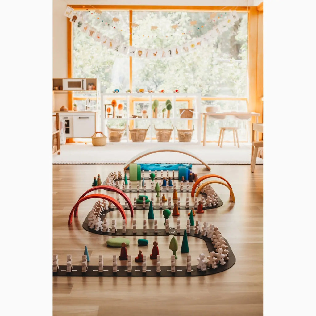 Wooden toy road with arches and figurines.