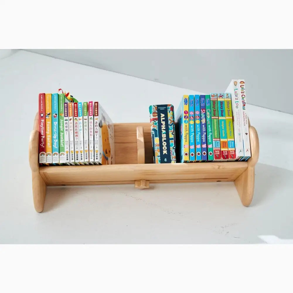 Wooden tabletop bookshelf holding colorful children’s books.