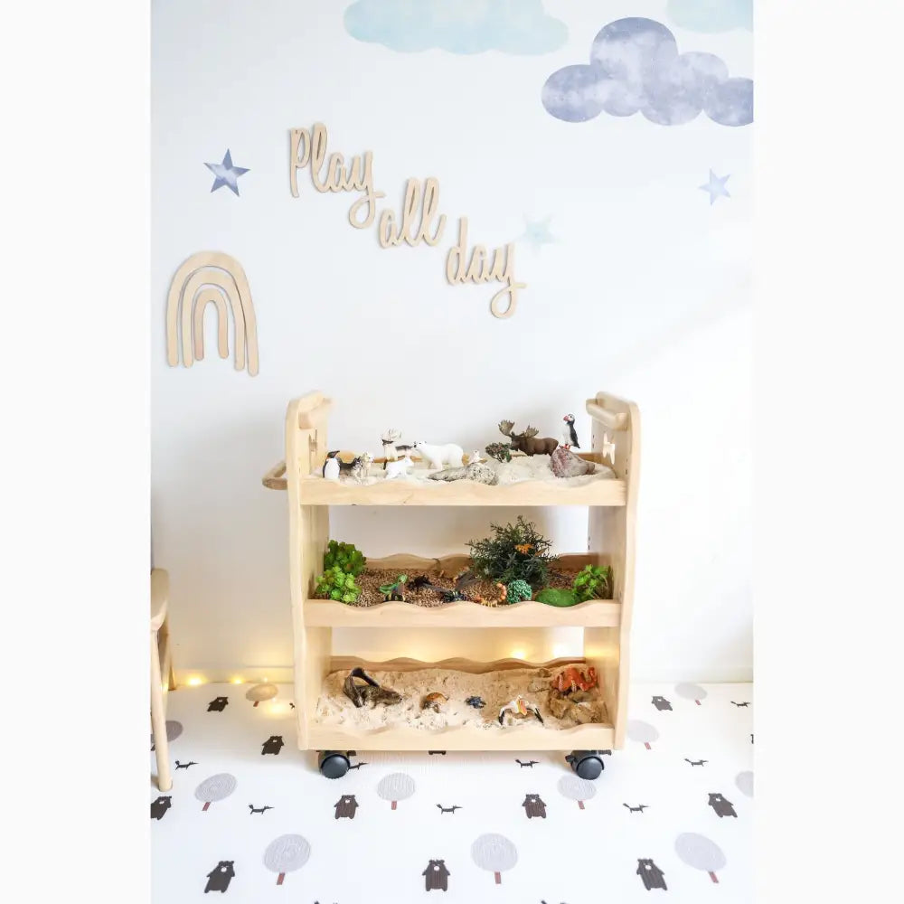 Wooden shelf unit with three tiers displaying toy animals and natural elements.