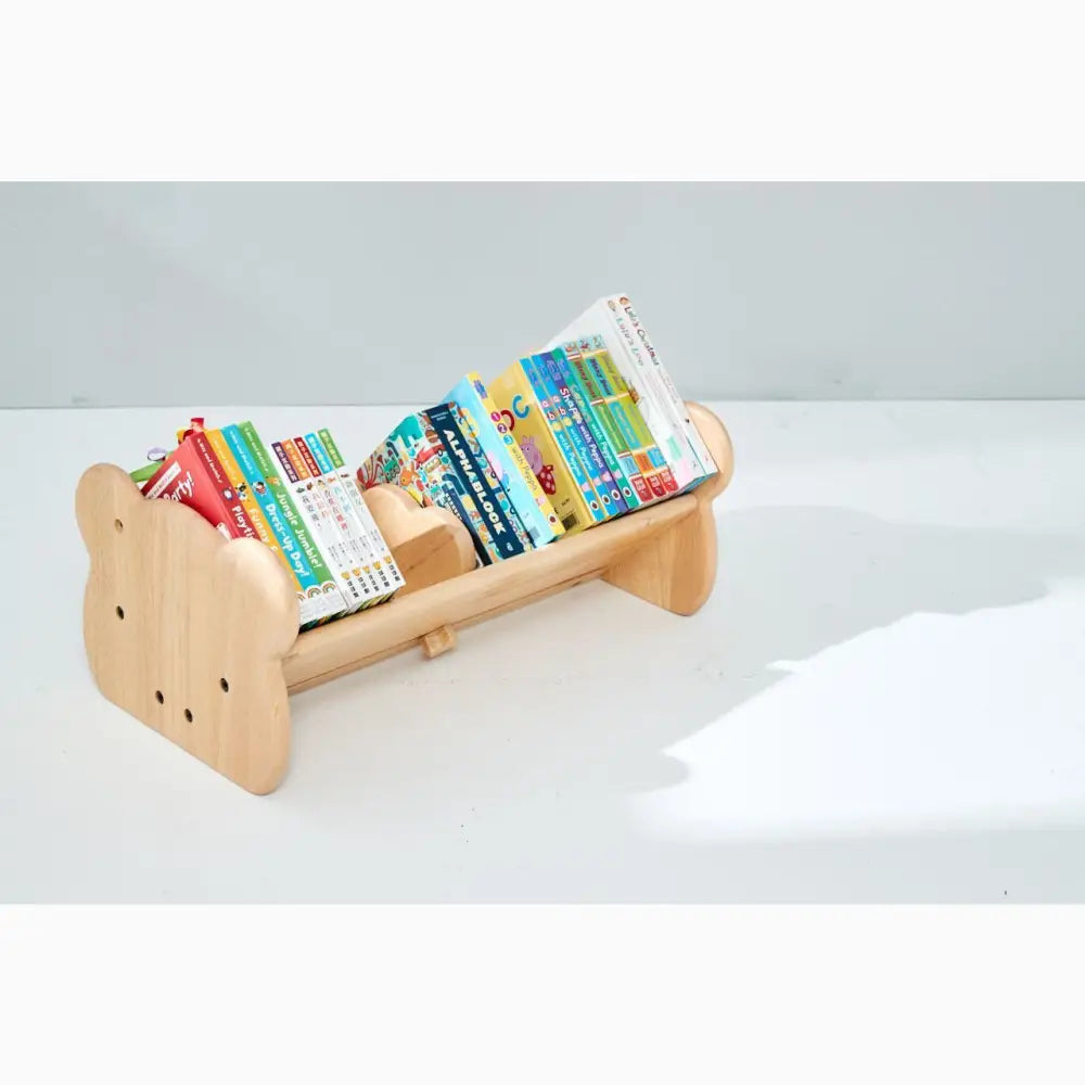 Wooden bear-shaped bookshelf holding colorful children’s books.