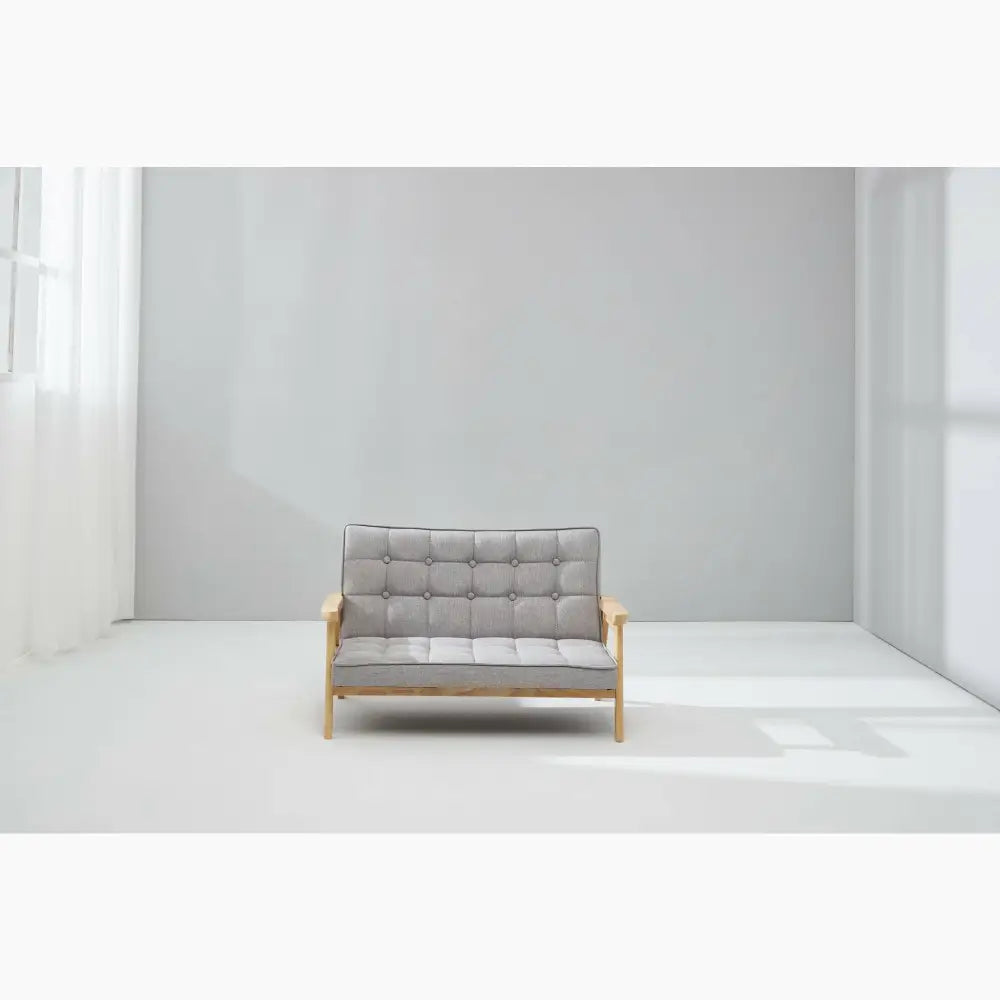 Gray tufted loveseat with wooden frame and arms.