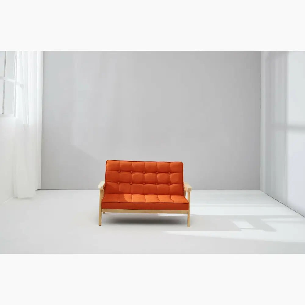 Orange tufted loveseat with wooden frame and arms.