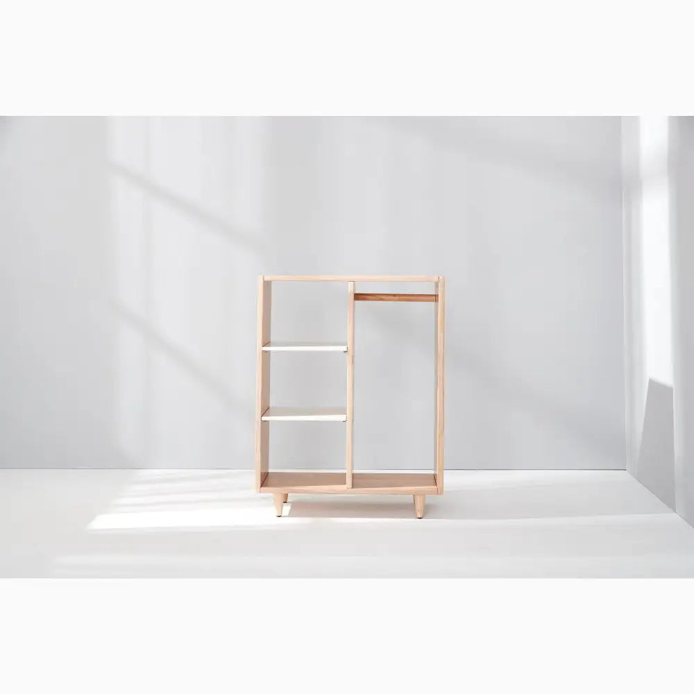 Minimalist wooden shelving unit with open compartments and a clean, modern design.