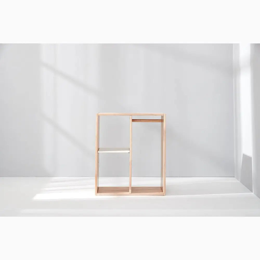 Minimalist wooden shelving unit with open rectangular compartments.