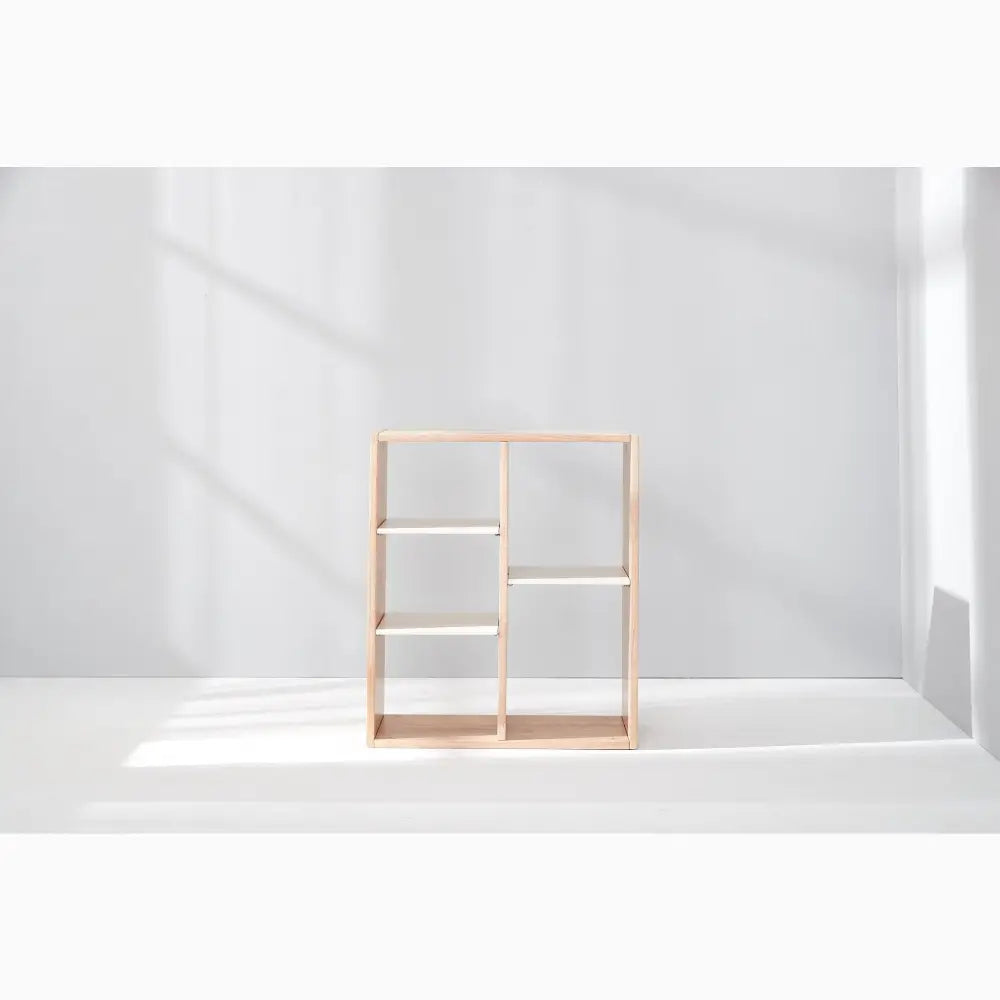 Wooden shelving unit with six compartments arranged in an asymmetrical grid pattern.