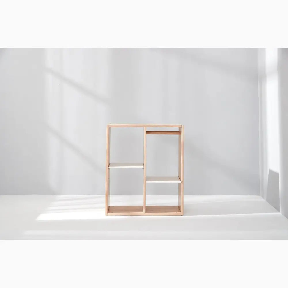 Minimalist wooden shelving unit with open rectangular compartments.