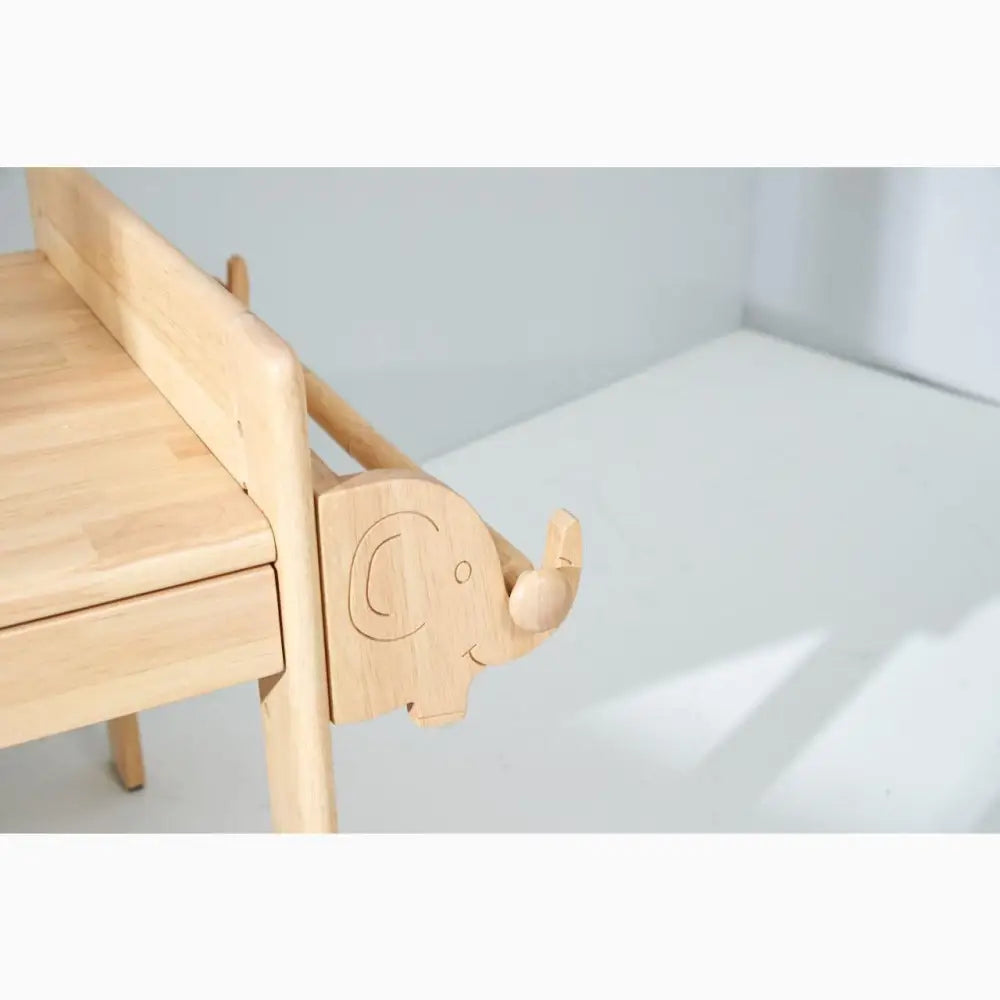 Wooden children’s chair with an elephant-shaped armrest.