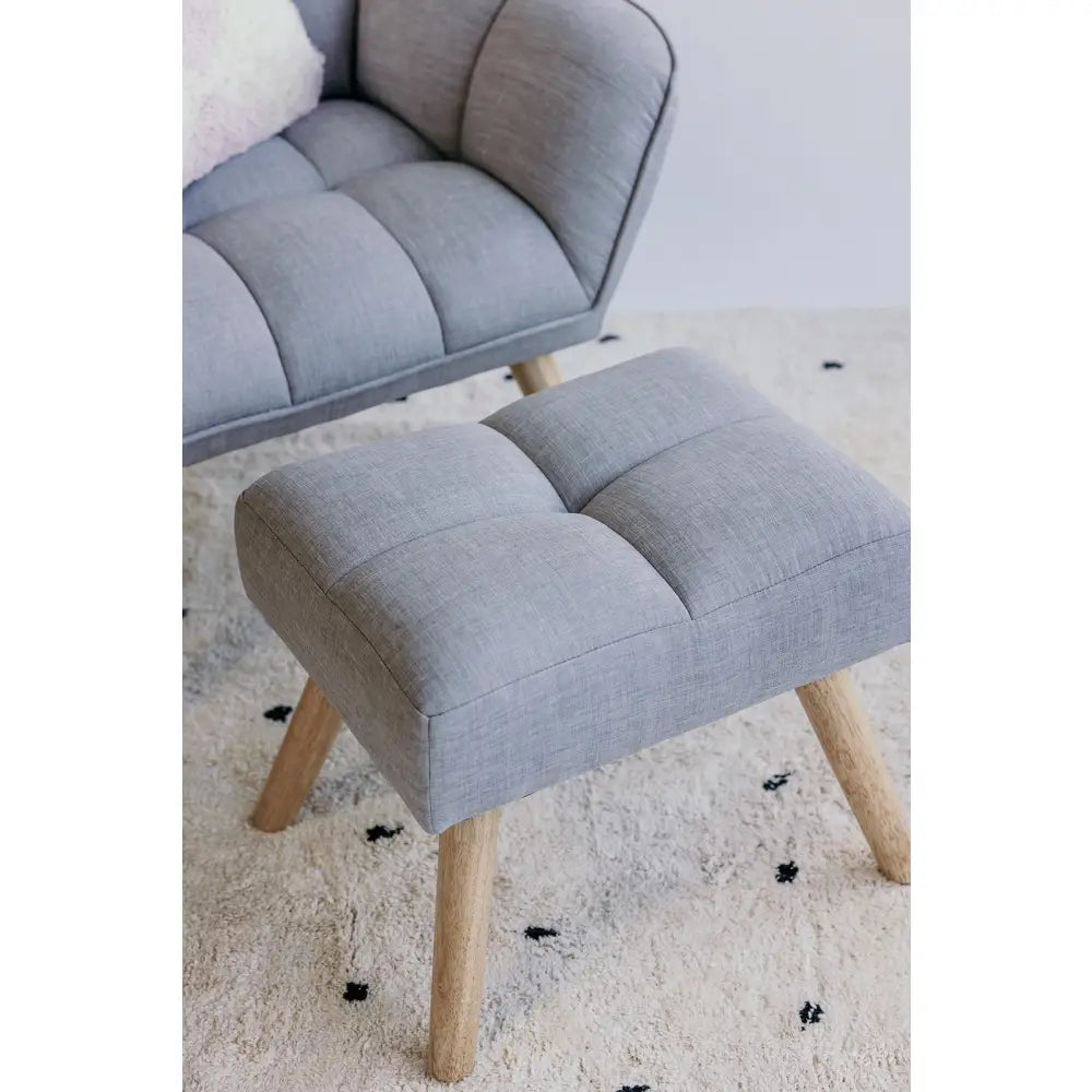 Gray upholstered armchair with matching footstool on wooden legs.