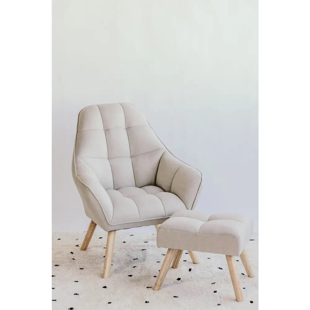 Beige upholstered armchair with matching footstool, both featuring wooden legs.