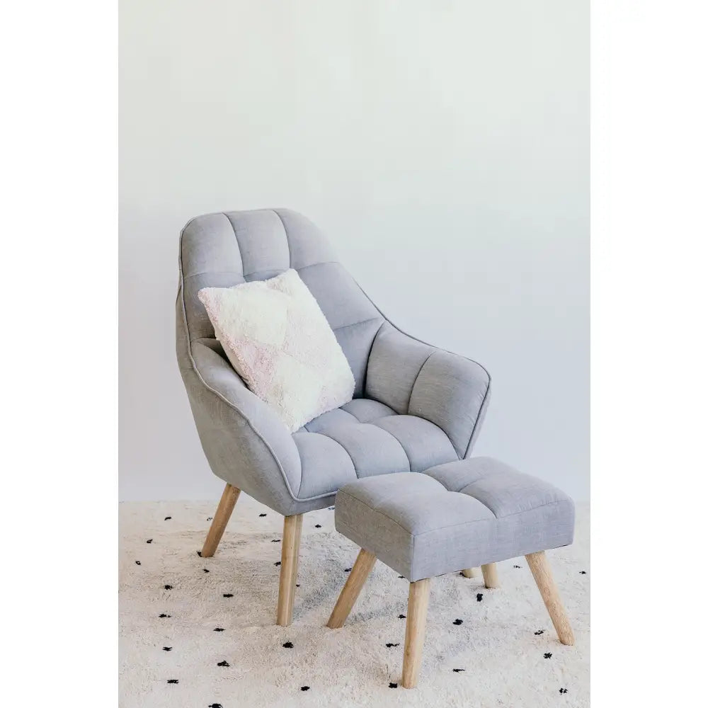 Comfortable-looking gray armchair with matching footstool and decorative pillow.