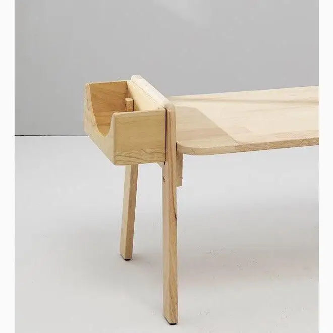 Minimalist wooden bench with a curved backrest and tapered legs.