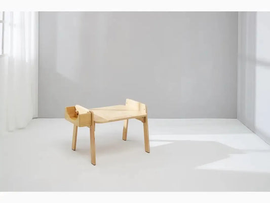 Minimalist wooden desk or table with raised edges on three sides.