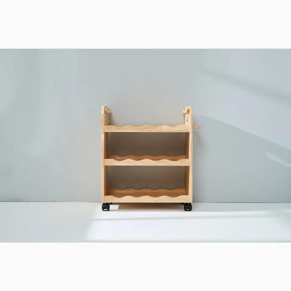 Wooden rolling cart with three shelves for storage.