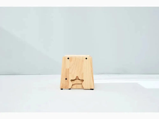 Wooden block or stool with a star-shaped cutout on its front face.