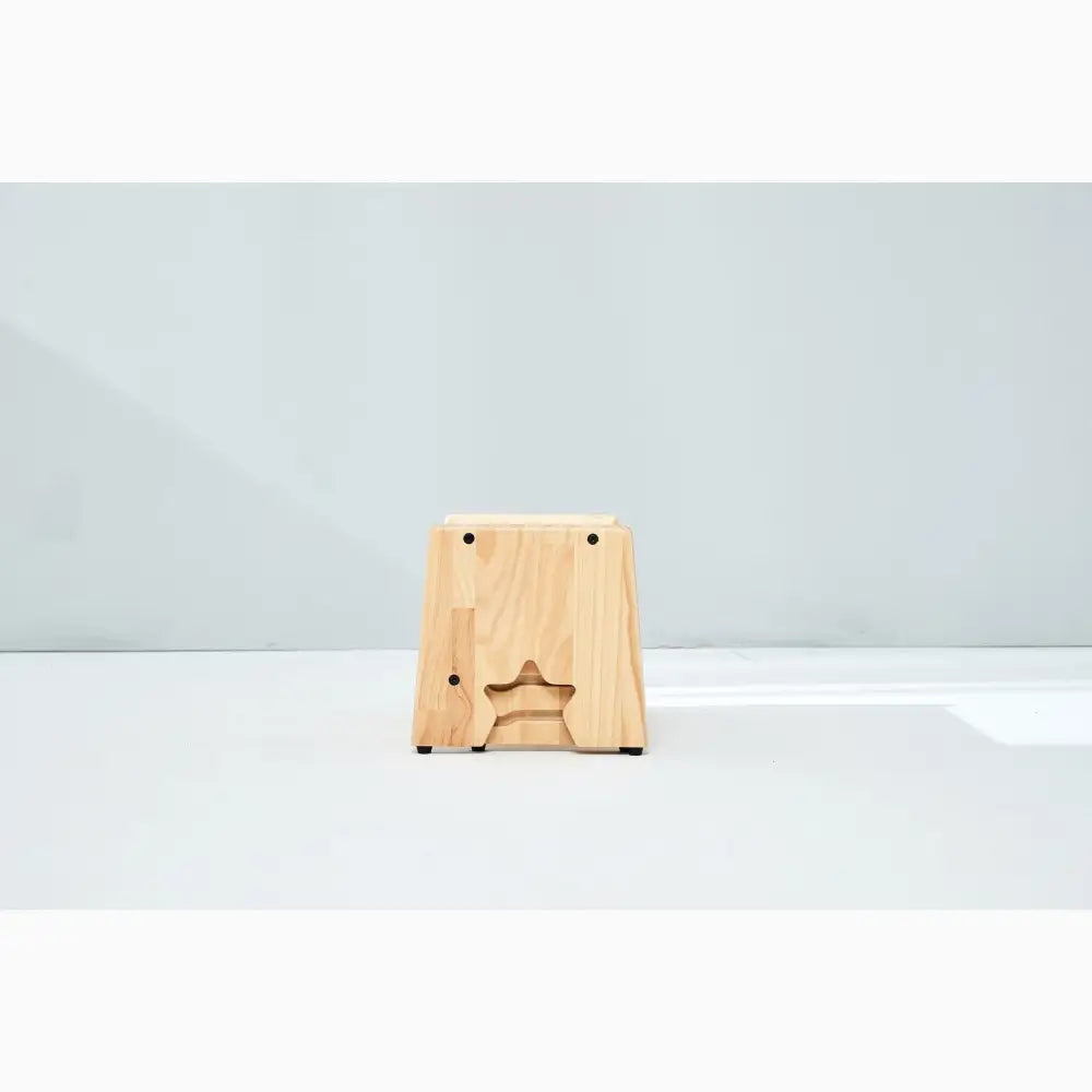 Wooden block or stool with a star-shaped cutout on its front face.