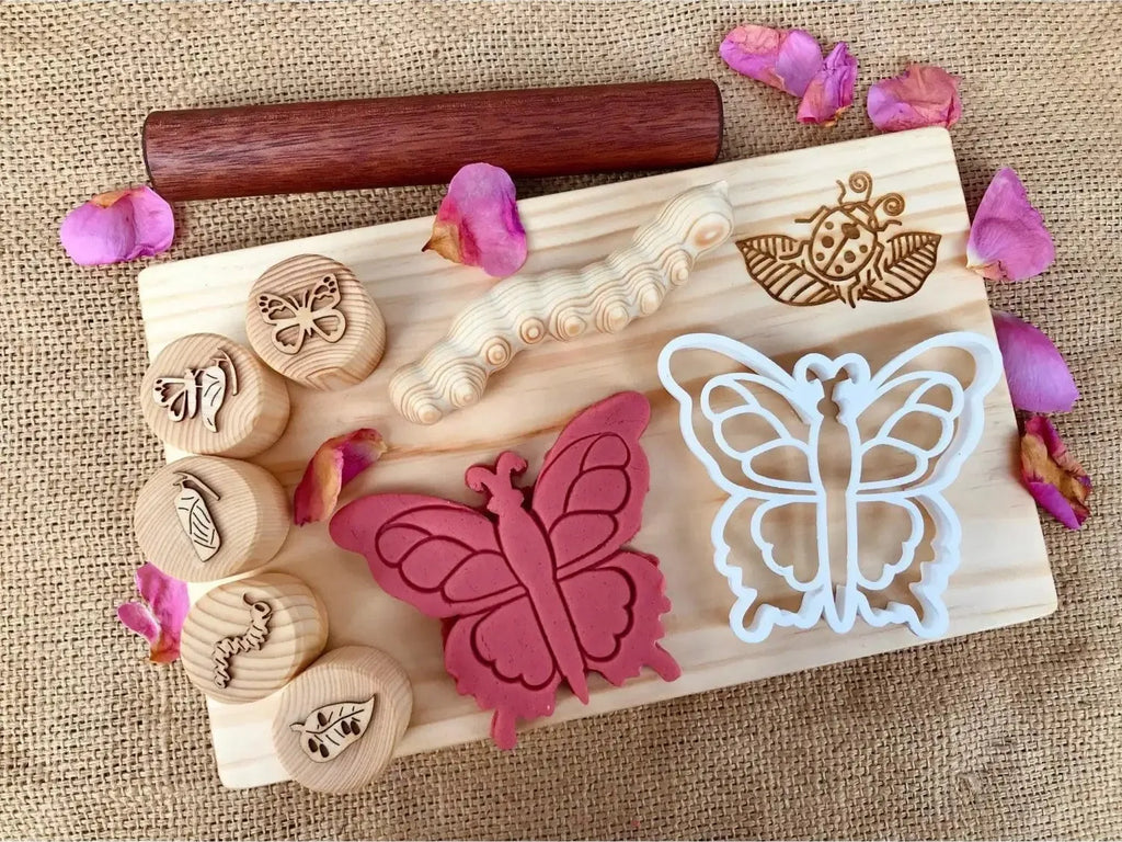 Wooden board with butterfly-themed stamps, cookie cutters, and decorative elements.