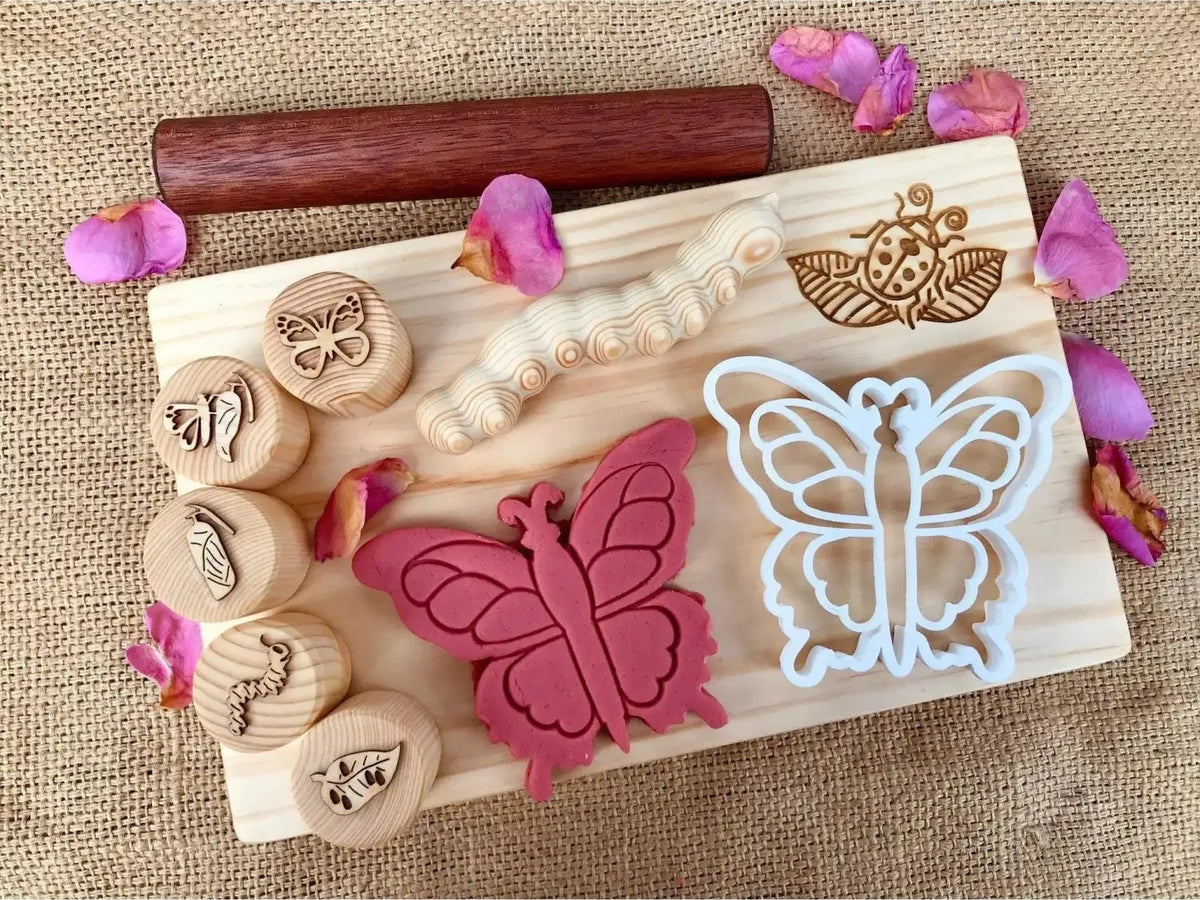 Wooden board with butterfly-themed stamps, cookie cutters, and decorative elements.
