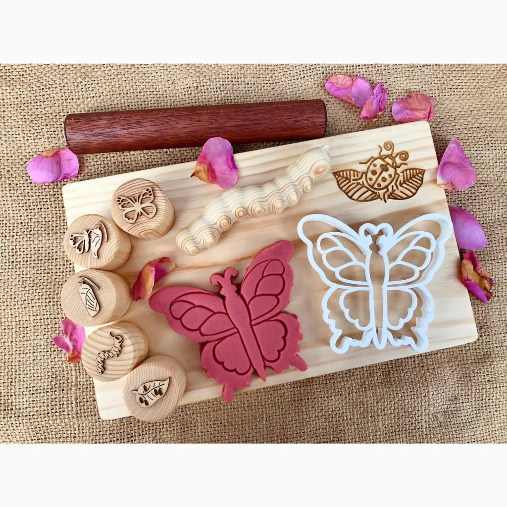 Wooden board with butterfly-themed stamps, cookie cutters, and decorative elements.