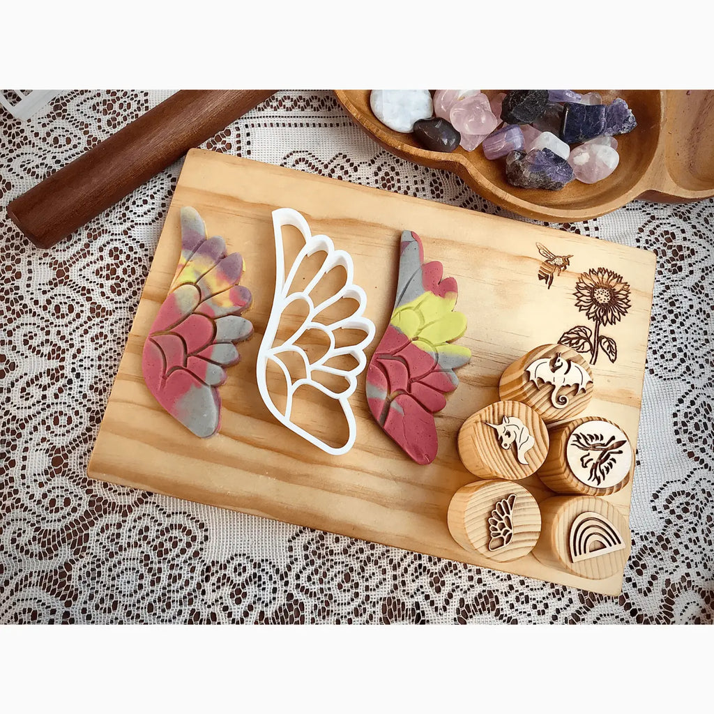 Wooden board displaying colorful butterfly wing shapes and carved wooden stamps.