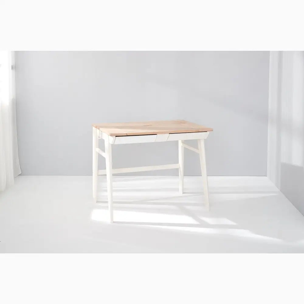 Simple wooden desk with white legs and a natural wood top.