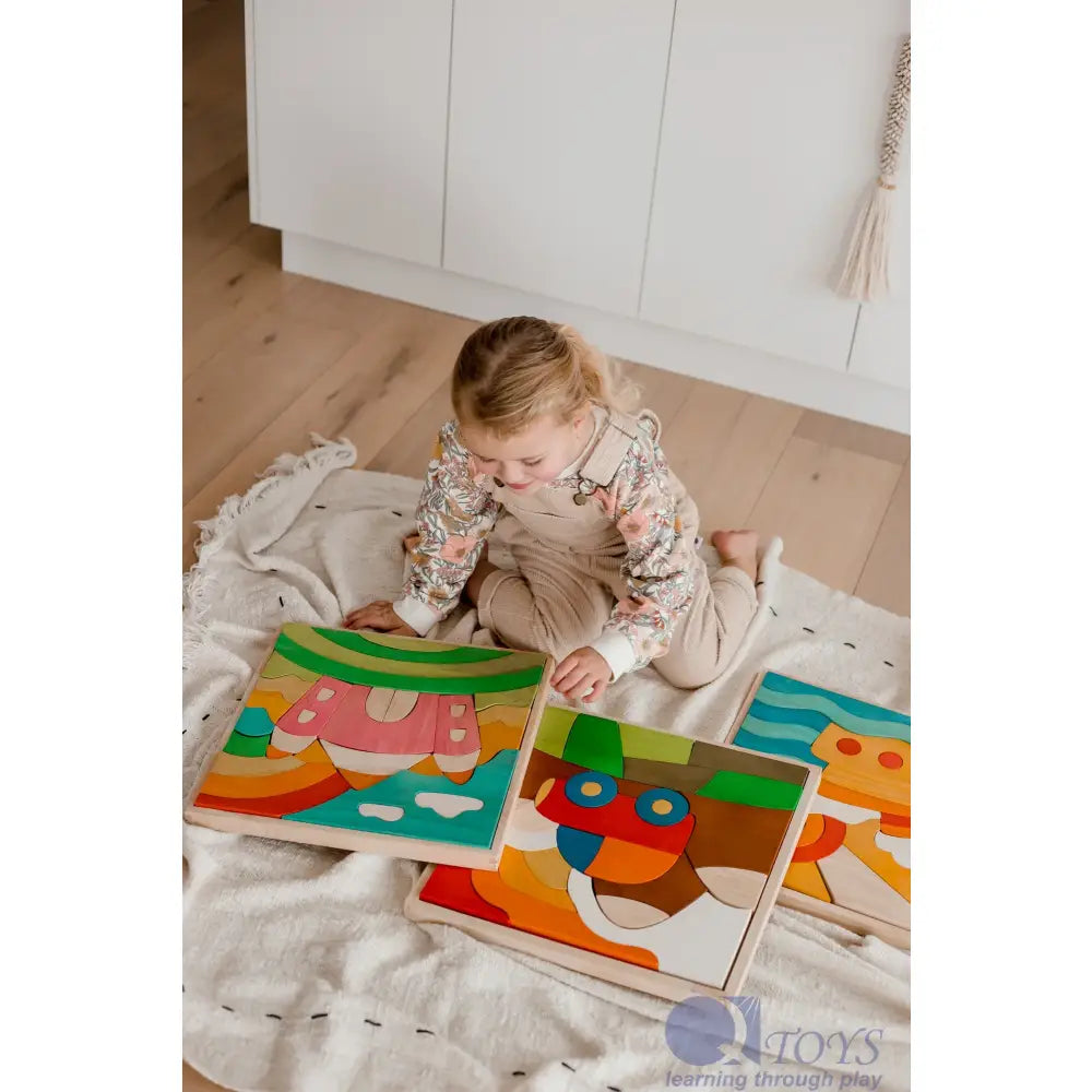 Toddler playing with colorful wooden puzzle pieces on a blanket.