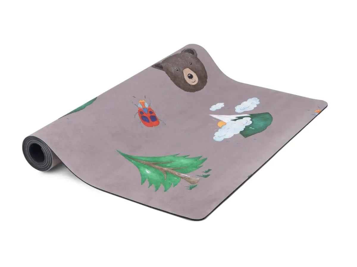 Yoga mat with woodland-themed decorative prints including a bear, tree, and rabbit.
