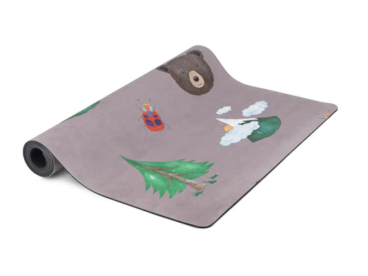 Yoga mat with woodland-themed decorative prints including a bear, tree, and rabbit.