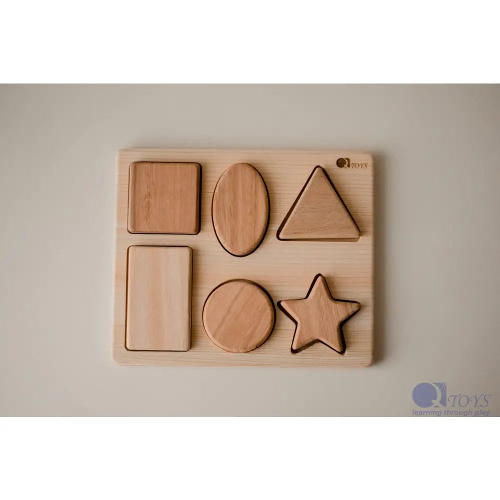 Wooden shape sorter puzzle with basic geometric forms.