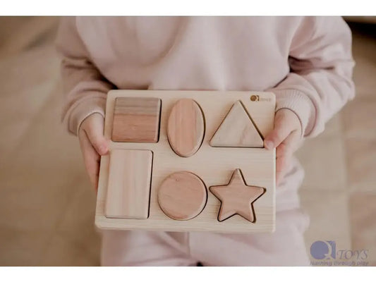 Wooden shape sorter puzzle with various geometric forms.