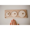 Wooden puzzle board with three circular pieces of increasing size.