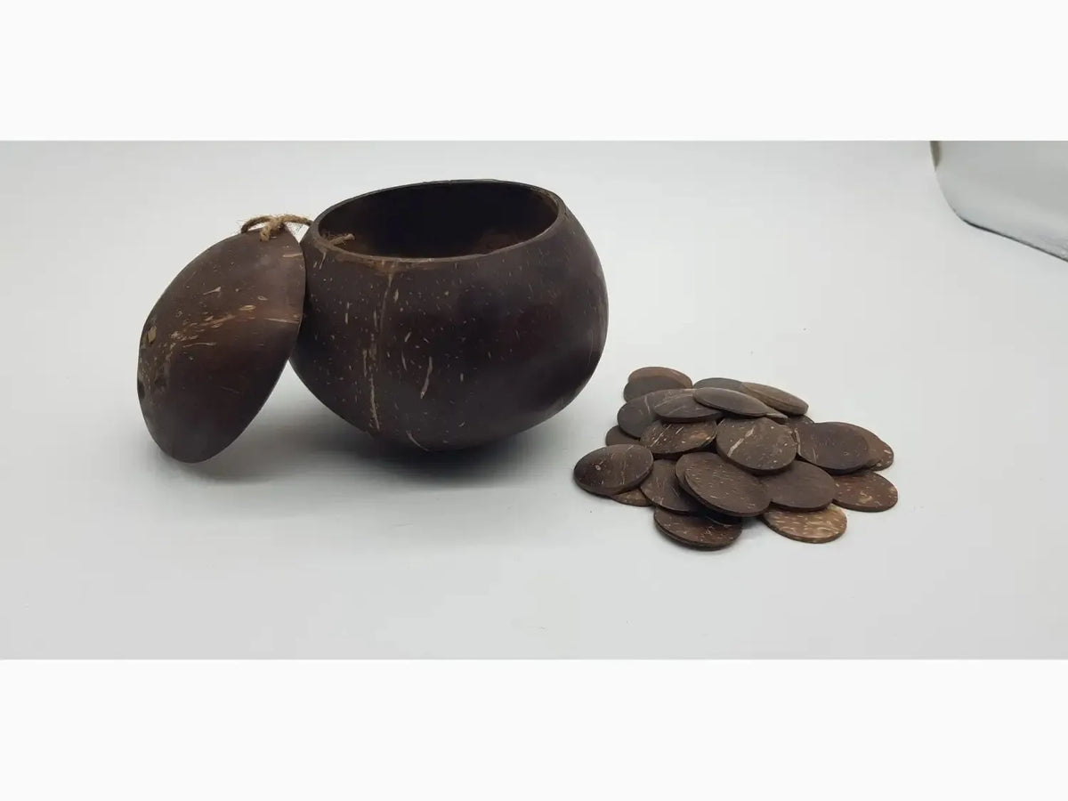 Coconut shell bowl with a lid next to a pile of coins.