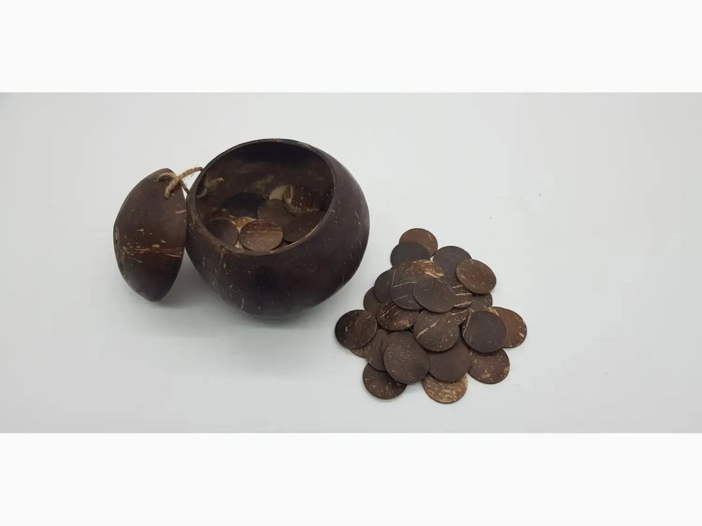 Broken coconut shell with scattered chocolate discs nearby.