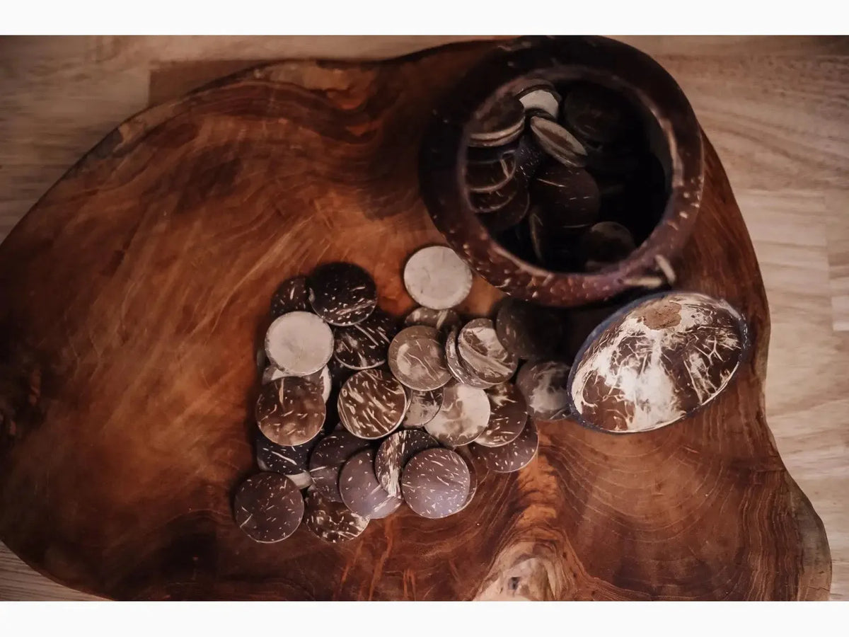 Wooden bowl or platter containing various coins and a small decorative object.