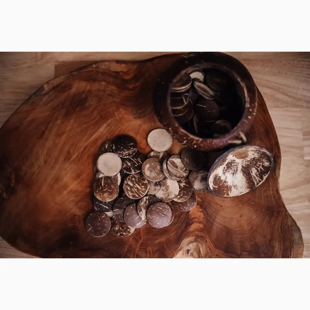 Wooden bowl or platter containing various coins and a small decorative object.