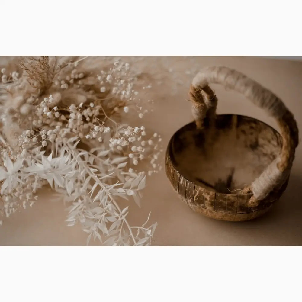 Rustic wooden bowl with a curved handle.