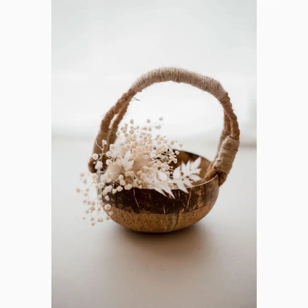 Rustic basket filled with delicate white flowers and dried foliage.