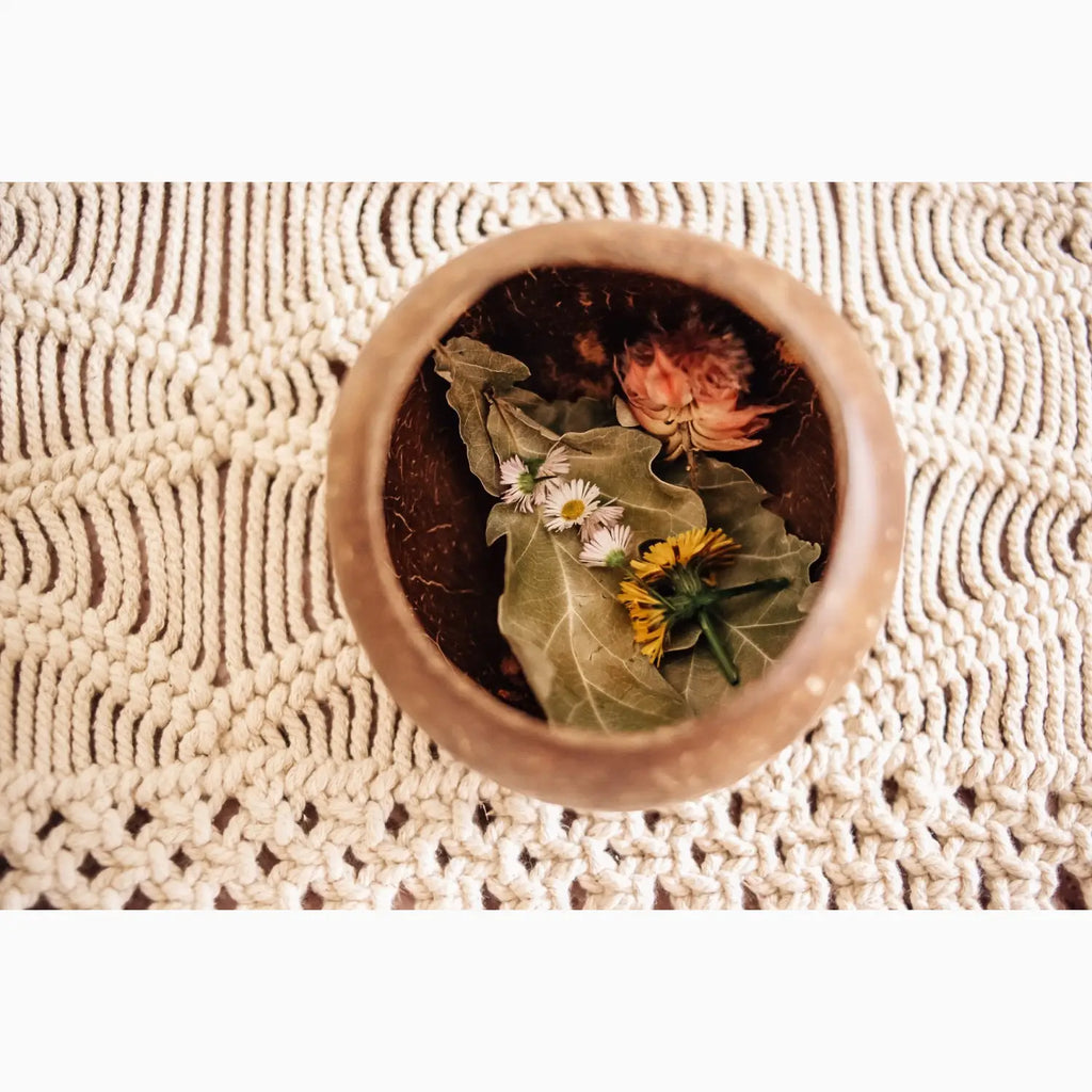 Coconut shell bowl with flowers and leaves.