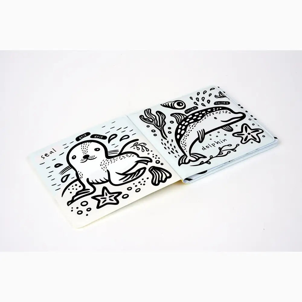Hand-drawn sea creature design on a white surface, featuring a seal and dolphin with decorative elements.