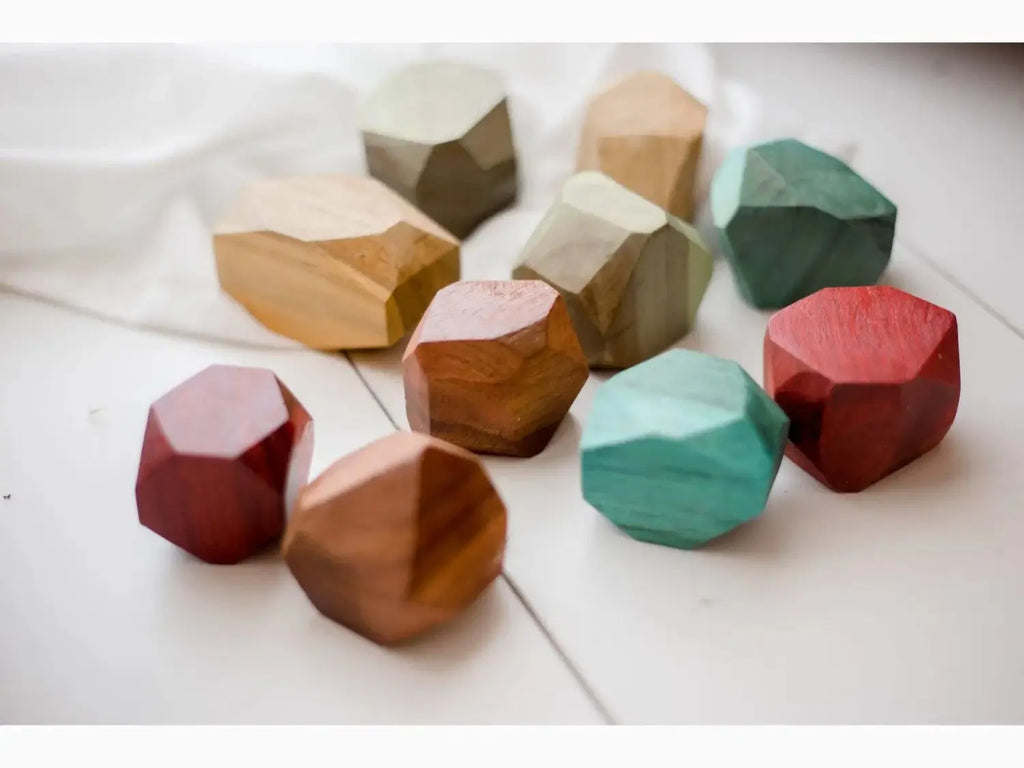 Colorful geometric wooden blocks or shapes with faceted surfaces.