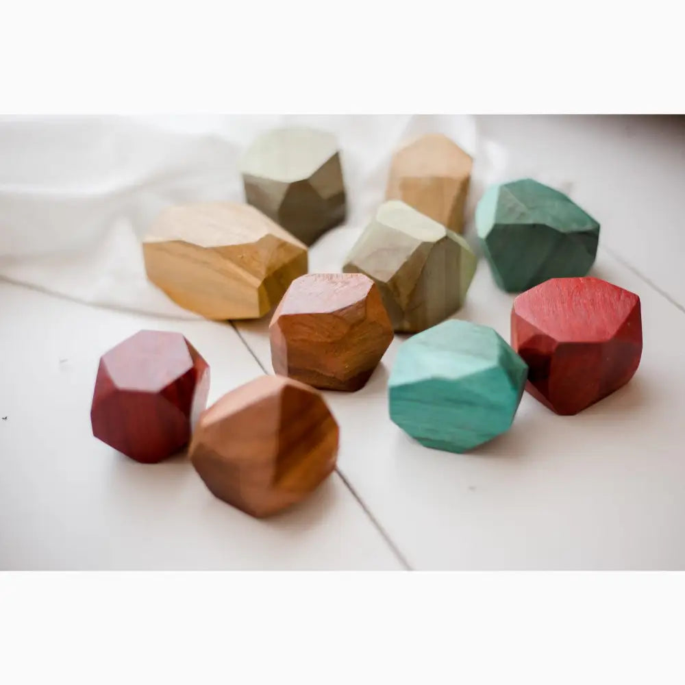 Colorful geometric wooden blocks or shapes with faceted surfaces.