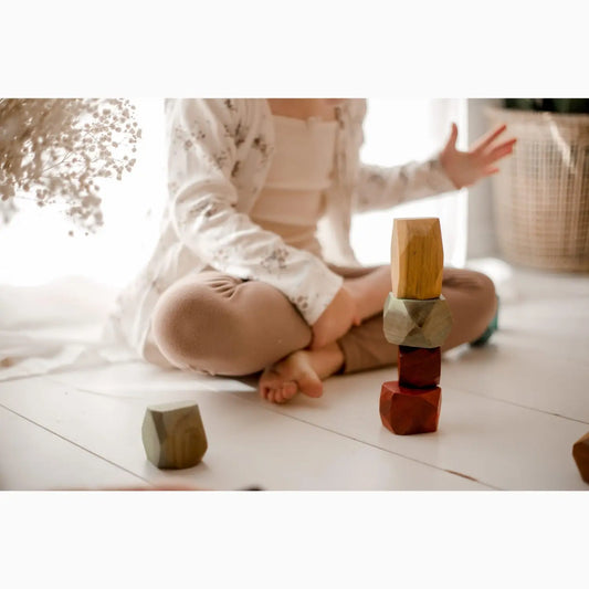 Wooden blocks stacked in a small tower on a floor.