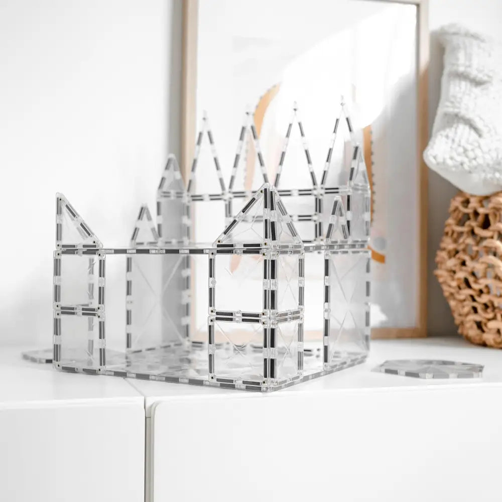 Transparent acrylic or glass castle-shaped organizer with geometric cutout patterns.