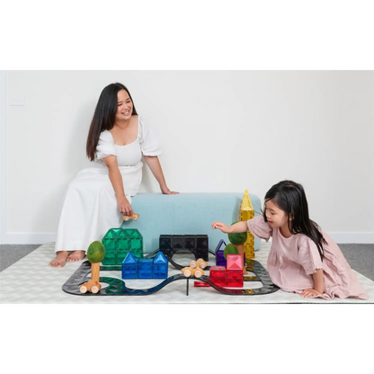 Woman and child playing with colorful building blocks and toys on the floor.