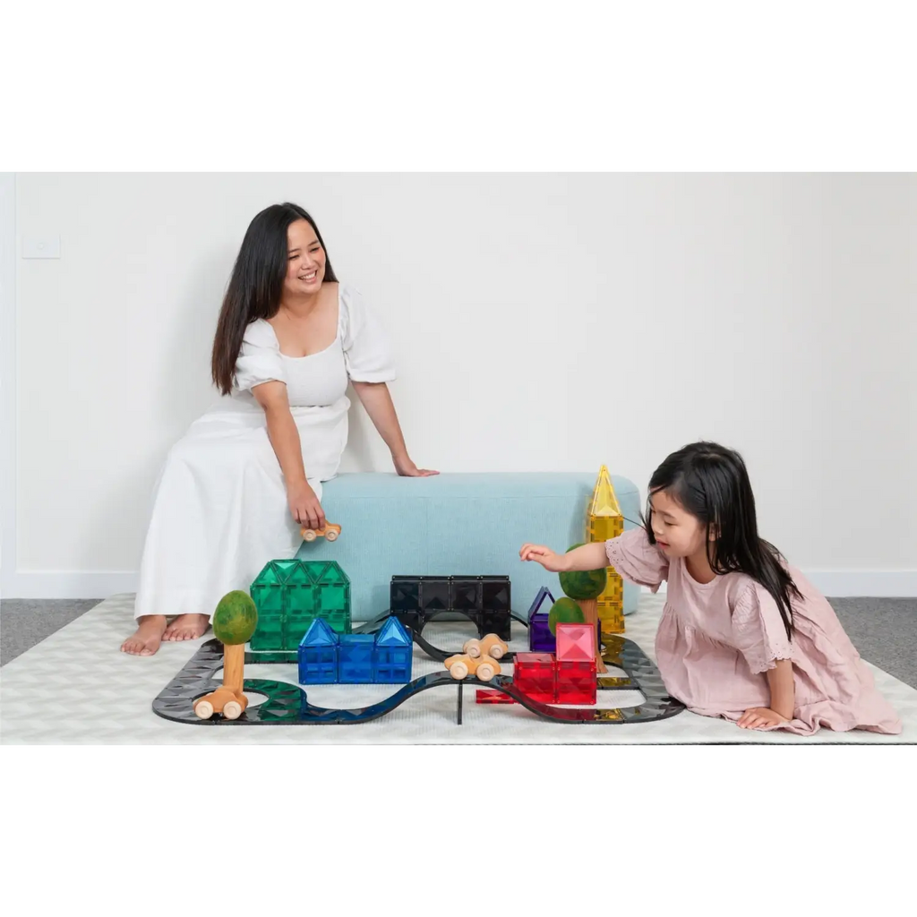 Woman and child playing with colorful building blocks and toys on the floor.